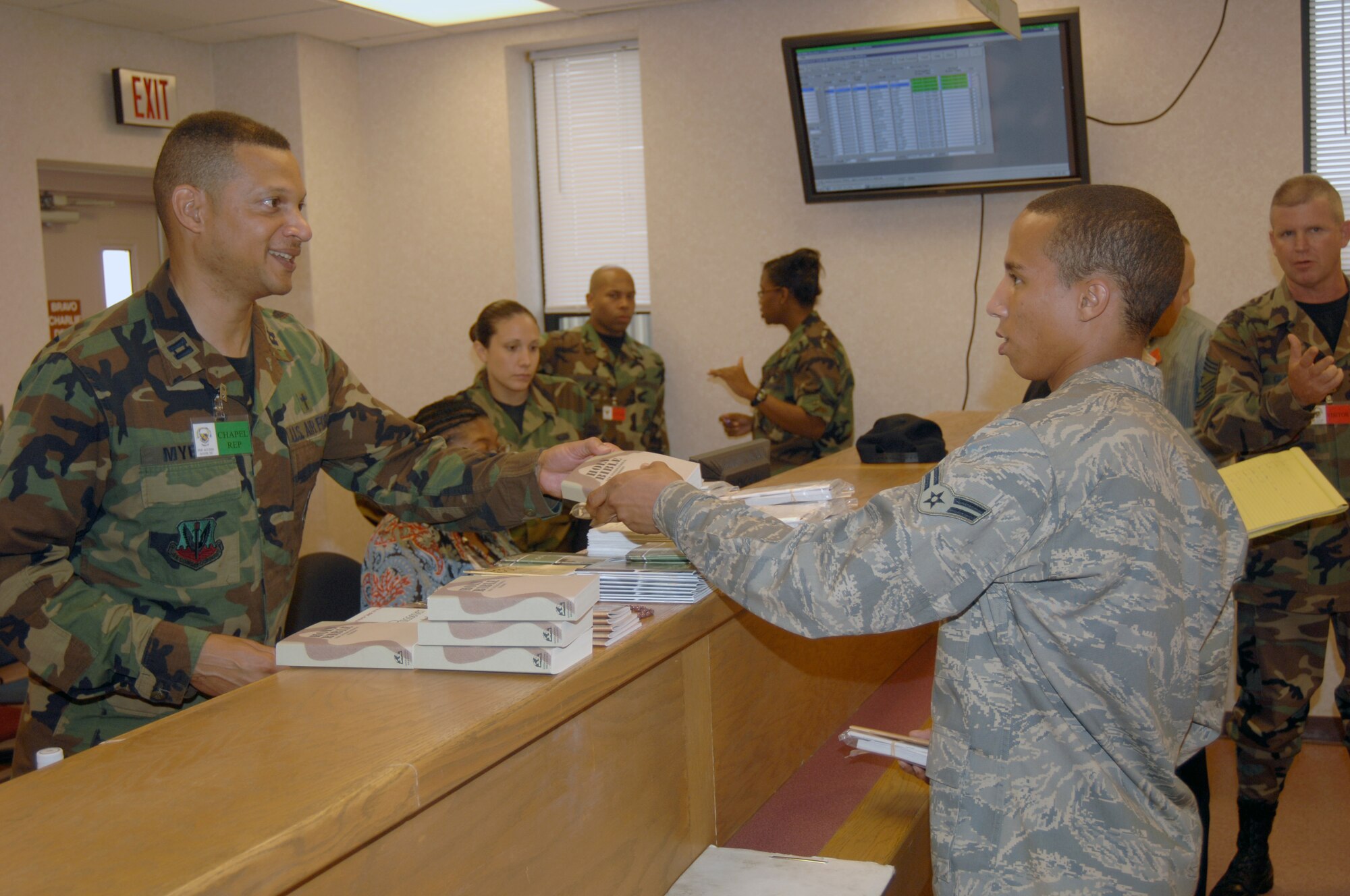 SEYMOUR JOHNSON AIR FORCE BASE, N.C. - Chaplain (Capt.) Michael Myers, 4th Fighter Wing, hands out information from the chapel to Airman 1st Class Chad Stewart, 4th Equipment Maintenance Squadron, during processing Aug. 29, 2007.  More than 600 4th FW Airmen will deploy in the next few months. (U.S. Air Force photo by Senior Airman Chad Trujillo)