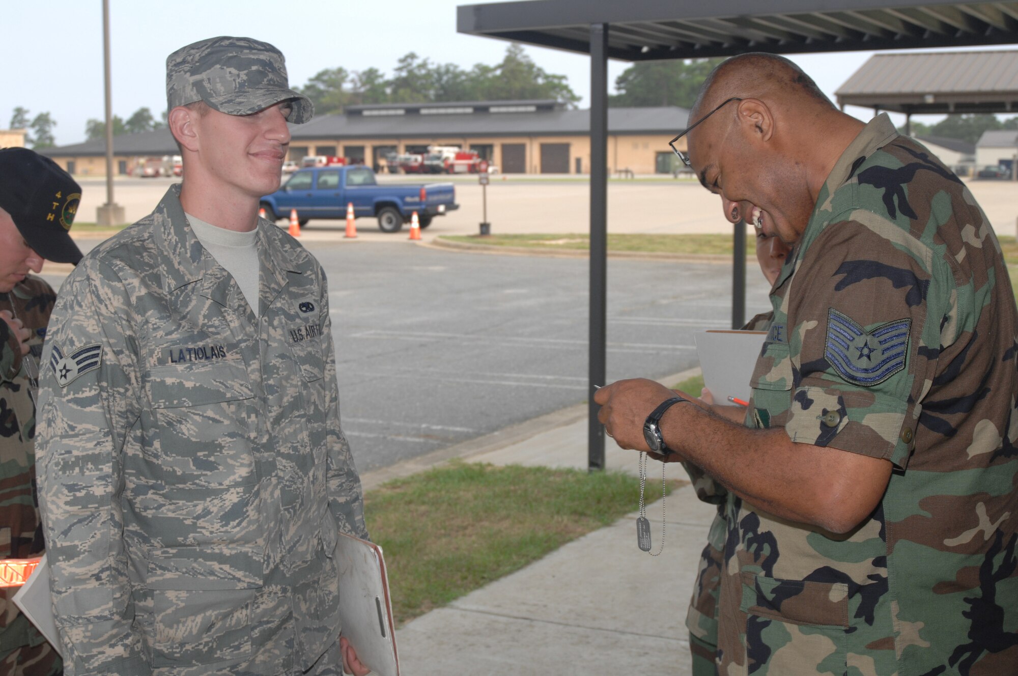SEYMOUR JOHNSON AIR FORCE BASE, N.C. - Technical Sergeant Wayne Powell, 4th Mission Support Squadron, checks Senior Airman Colby Latiolais's, 4th Equipment Maintenance Squadron, dog tags to make sure the information is correct before he deploys at Seymour Johnson Air Force Base, during processing Aug. 29, 2007.  More than 600 4th Fighter Wing Airmen will deploy in the next few months. (U.S. Air Force photo by Senior Airman Chad Trujillo)