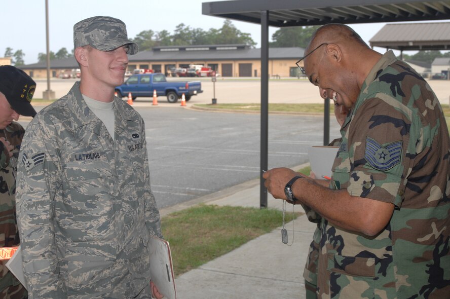 SEYMOUR JOHNSON AIR FORCE BASE, N.C. - Tech. Sgt. Wayne Powell, 4th Mission Support Squadron, checks Senior Airman Colby Latiolais's, 4th Equipment Maintenance Squadron, dog tags to make sure the information is correct before he deploys at Seymour Johnson Air Force Base, during processing Aug. 29, 2007. More than 600 4th Fighter Wing Airmen will deploy in the next few months. (U.S. Air Force photo by Senior Airman Chad Trujillo) 