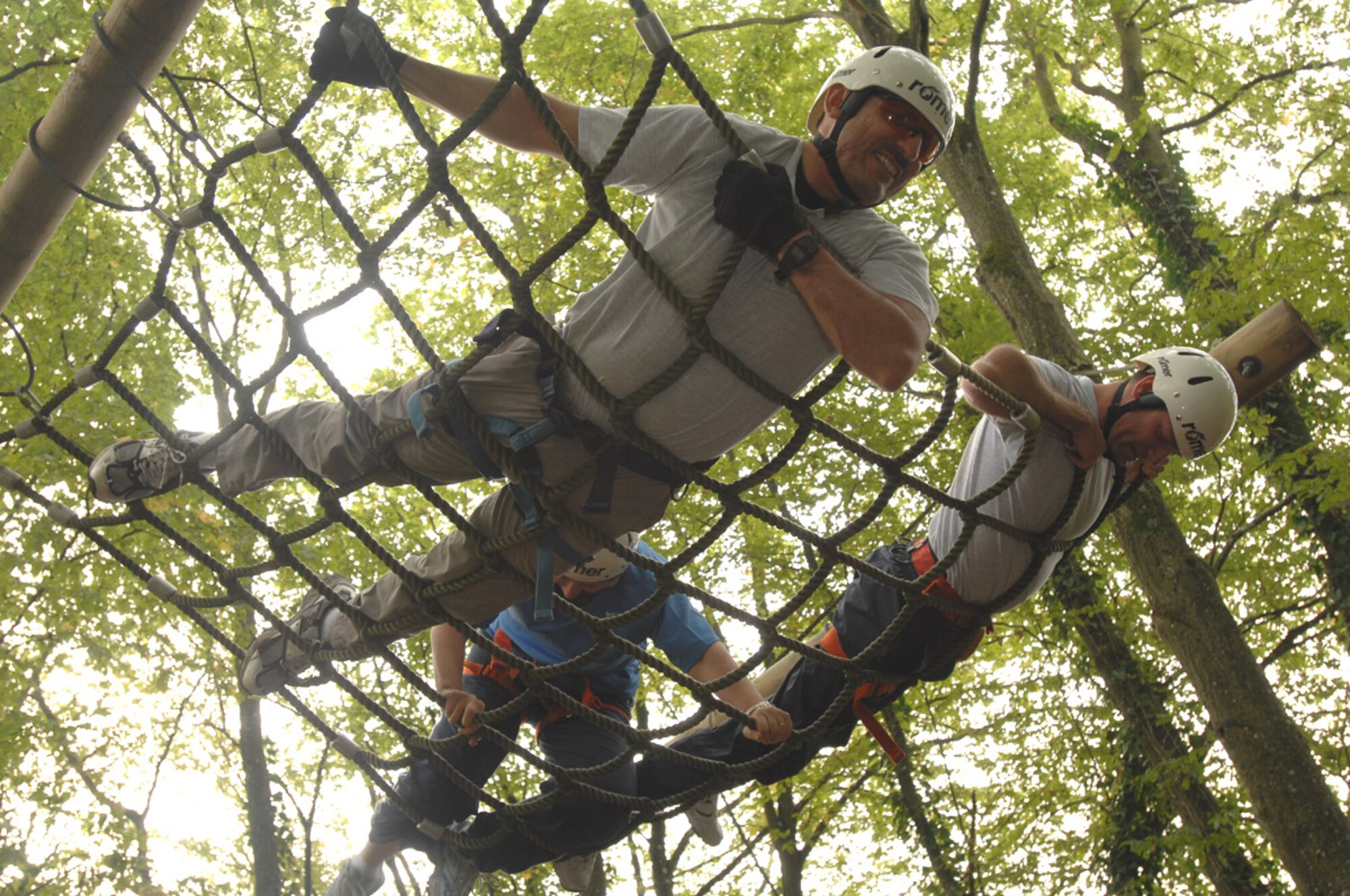SPANGDAHLEM AIR BASE, Germany – Chief Master Sgt. Marc Rodriquez, 52nd Mission Support Group chief enlisted manager, along with Chief Master Sgt. Darrin Dwyer, 52nd Maintenance Group CEM, wait in a hanging net to help their team members up and over an obstacle during a ropes course Aug. 27. The course is designed to build team spirit and help its participants learn more innovative ways to work together to accomplish their mission. (U.S. Air Force photo/Senior Airman Josie Kemp)