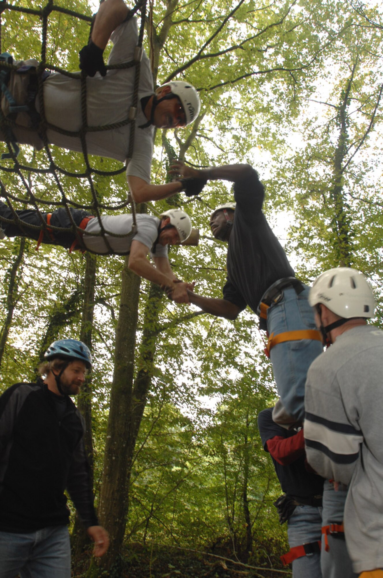 SPANGDAHLEM AIR BASE, Germany – Chief Master Sgt. Marc Rodriquez, 52nd Mission Support Group chief enlisted manager, along with Chief Master Sgt. Darrin Dwyer, 52nd Maintenance Group CEM, lends a hand to help fellow team members up and over an obstacle during a ropes course Aug. 27. The course is designed to build team spirit and help its participants learn more innovative ways to work together to accomplish their mission. (U.S. Air Force photo/Senior Airman Josie Kemp)