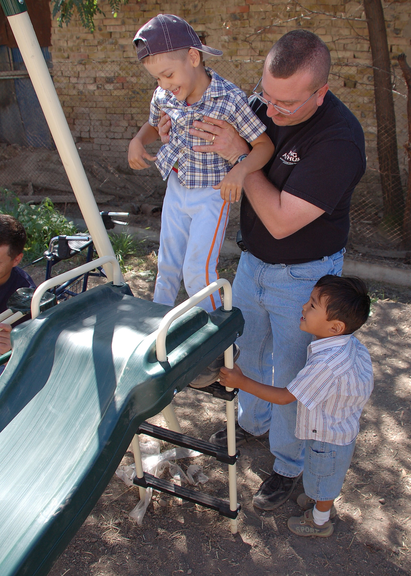 MANAS AIR BASE, Kyrgyzstan - Master Sgt. Mark Grim helps one of the boys up the slide during a visit to the Umut-Nadjeshda Children's Rehabilitation Center in Bishkek, Kyrgyzstan Aug. 22.  Sgt. Grim is a member of the 4th Services Squadron at Seymour Johnson AFB, N.C., is currently deployed to the 376th Expeditionary Services Squadron at Manas AB, Kyrgyzstan.  (Air Force photo by Staff Sgt. Les Waters)