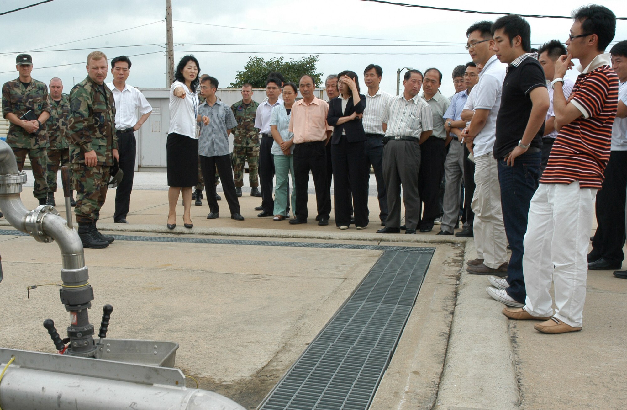 KUNSAN AIR BASE, South Korea-- Master Sgt. Daniel Drain, 8th Logistics Readiness Squadron NCO in charge of fixed facilities, briefs on base fueling systems while Rosemary Song, 8th Fighter Wing Public Affairs chief of community relations, translates to local city officials from Gunsan City. The purpose of the tour was to educate local community city officials on the base's mission and environmental awareness. (U.S. Air Force photo/Staff Sgt. Araceli Alarcon)                                