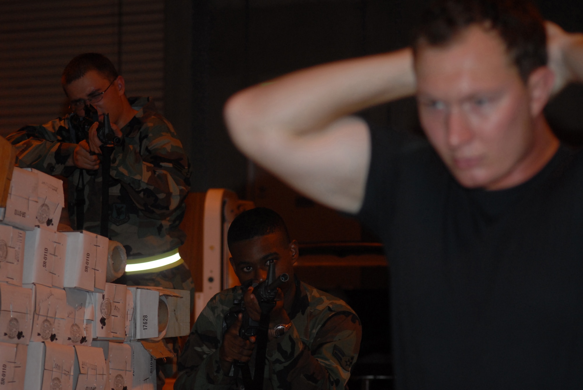 Airmen 1st Class Johnathan Meyer (left) and Gilbert Hardy challenge Senior Airman Charles Johnson during a base exercise at Kadena Air Base, Japan, Aug. 24, 2007. Both airmen took the selective arms course which enables them to protect their squadron's personnel and assets. The base conducted a three-day base exercise to demonstrate its ability to deploy and generate aircraft. All three Airmen are assigned to the 18th Civil Engineer Squadron.   (U.S. Air Force Photo/Senior Airman Darnell T. Cannady)