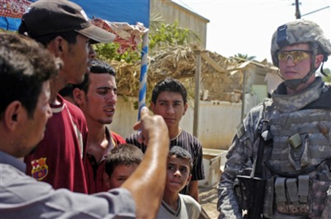 U.S. Army Sgt. Christopher Fabian talks with local citizens about insurgent activity in Baghdad, Iraq, on Aug. 25, 2007.  Fabian is assigned to the 308th Psychological Operations Company, 10th Psychological Operations Battalion.  