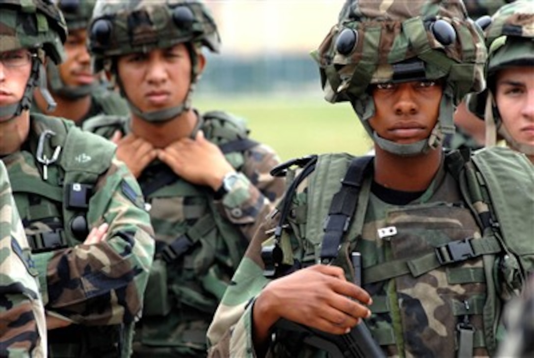 U.S. Air Force Airman 1st Class Jessica Wills (right) attentively listens to Staff Sgt. Jarrod Getz as he briefs the security forces members after a force-on-force training exercise at Aviano Air Base, Italy, on Aug. 29, 2007.  