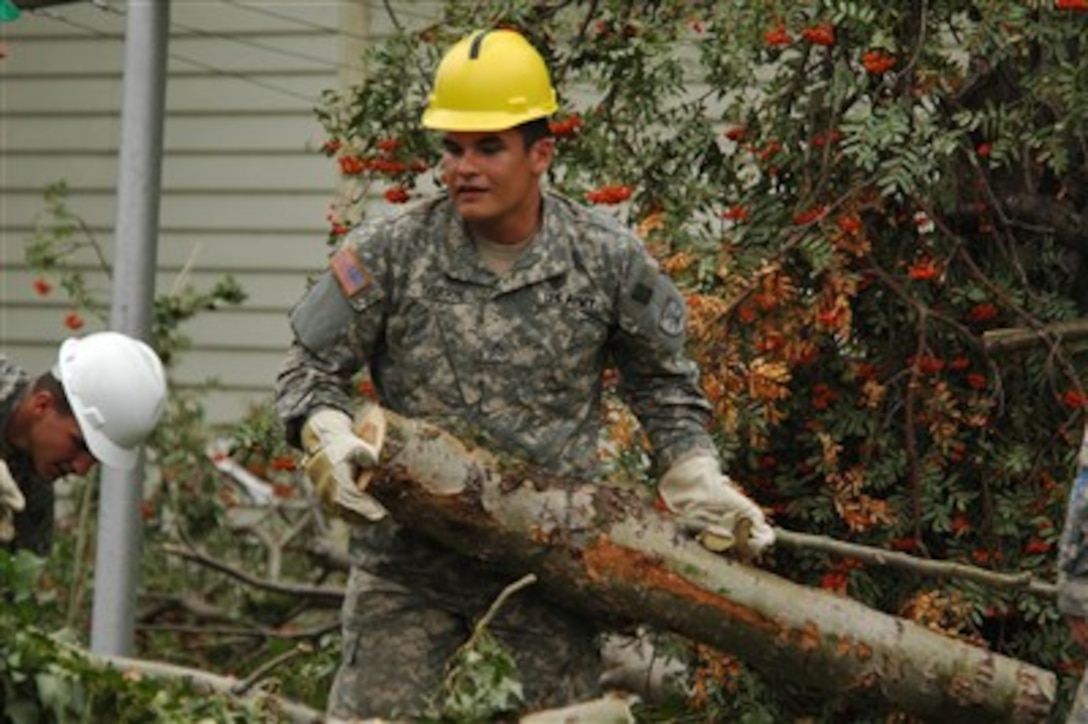 U.S. Army Pvt. Kevin J. Iverson, of the 188th Engineer Company, loads branches and limbs of trees into the bucket of a dump truck in Northwood, N.D., on Aug. 27, 2007.  Authorities believe the damage was caused by a tornado that hit the area on Aug. 26.  