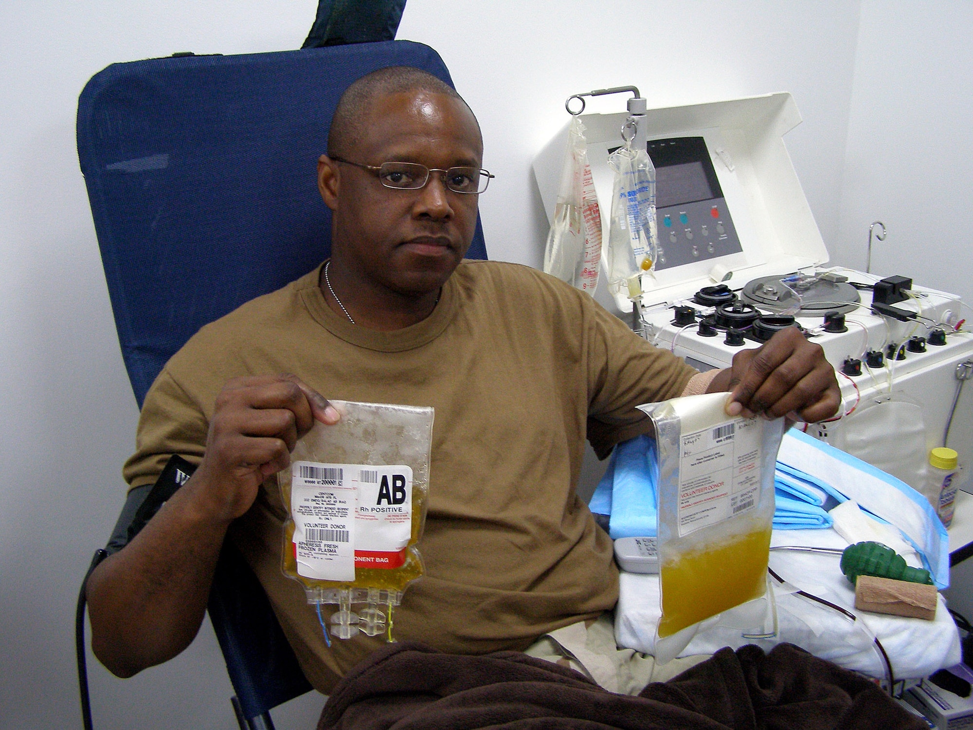 Tech. Sgt. Darrin Sewer sits in the donor's chair at the Air Force Theater Hospital Apheresis Center at Balad Air Base, Iraq, Aug. 5 after donating the first plasma in the area of responsibility. Sergeant Sewer has type AB plasma, the universal plasma type. The plasma will be used to supplement current supplies that are sent from the states. Sergeant Sewer is the NCO in charge of the 332nd Expeditionary Communications Squadron help desk. (U.S. Air Force photo/Staff Sgt. Michael Garcia)