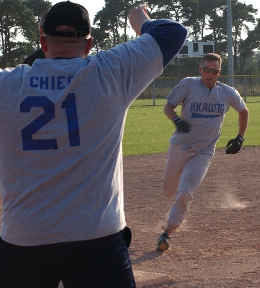Mike Miranda, from the 100th Operations Group, runs to 3rd base while Michael Parris cheers him on during the 2007 RAF Mildenhall softball intramural championship game played against the 727th Air Mobility Squadron, Aug. 29, 2007, at RAF Lakenheath. (U.S Air Force photo By Airman Brad Smith)