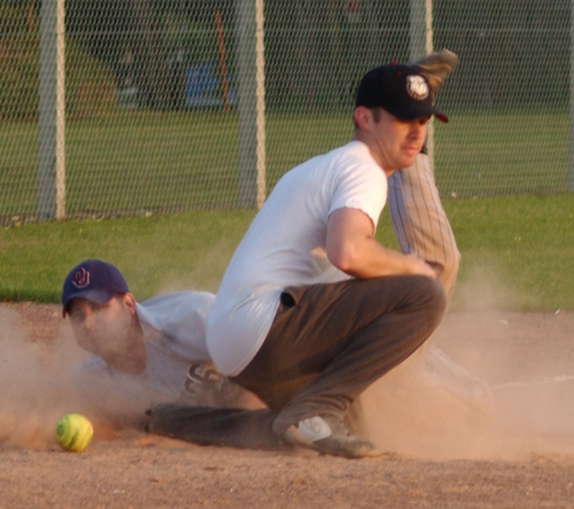 The 100th Operations Group catcher, Bobby York, slides into third base while the 352nd Maintenance Squadron third baseman, Larry Kight, tries to tag him out during the RAF Mildenhall softball championship game, Aug. 29, 2007, at RAF Lakenheath. (U.S. Air Force photo by Airman Brad Smith)