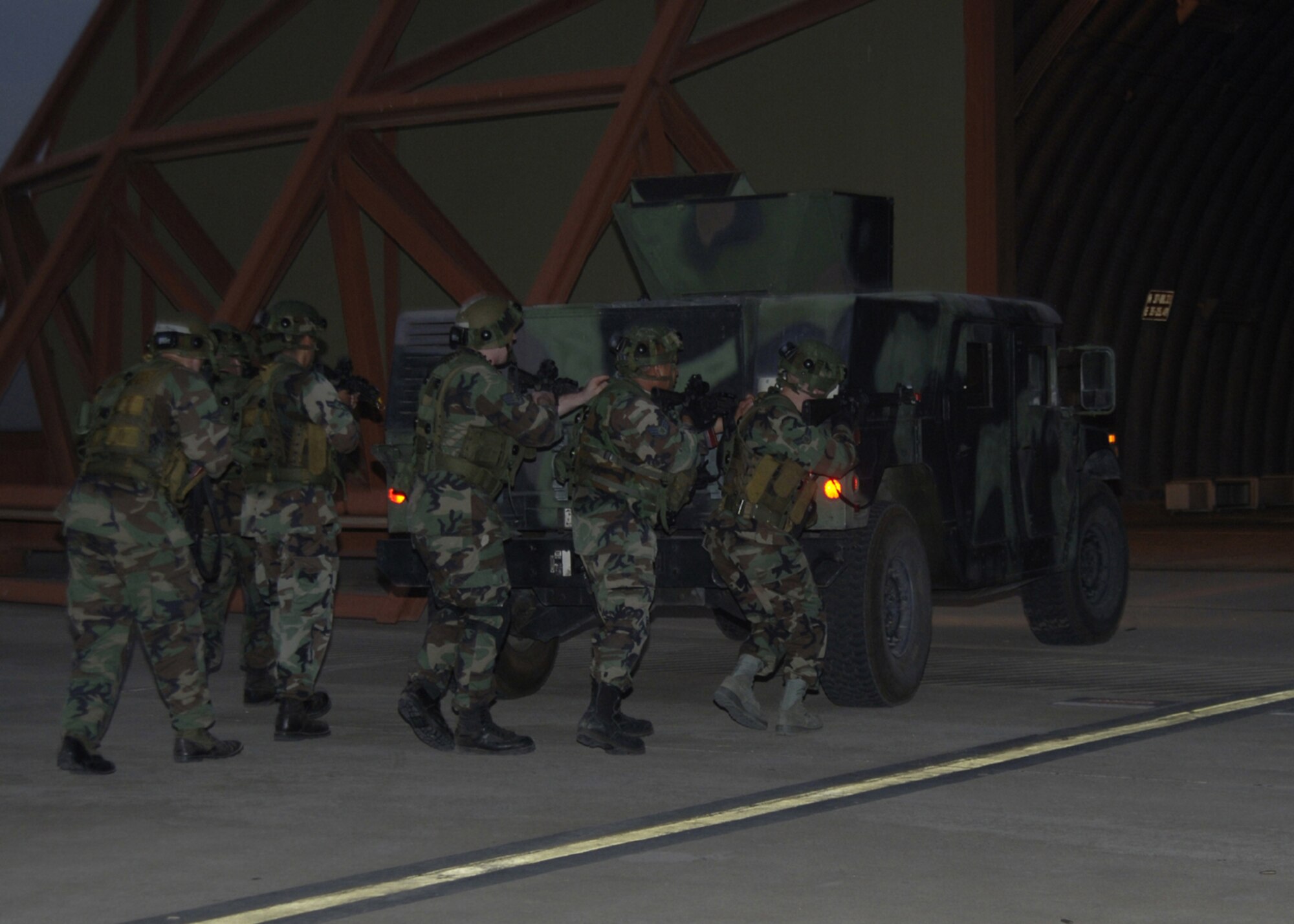 Members of the 39th Security Forces Squadron night shift use a Humvee as protection while going inside a hangar during a force on force recapture exercise Aug. 21. The SFS members participate in this exercise once a year and respond to three different scenarios. (U.S. Air Force photo by Senior Airman Tiffany Colburn)(RELEASED)

