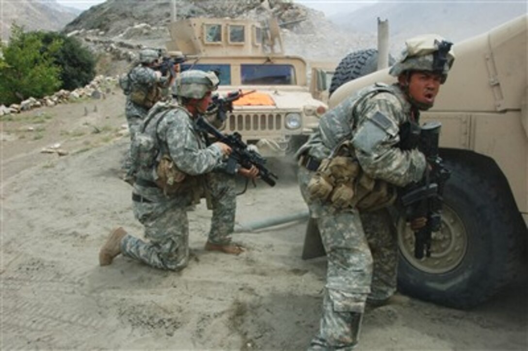 U.S. Army Spc. Chris Avila (right) and other soldiers engage Taliban forces during a halt to repair a disabled vehicle near the village of Allah Say, Afghanistan, on Aug. 20, 2007.  Avila is assigned to Foxtrot Company, 2nd Battalion, 82nd Aviation Brigade.  