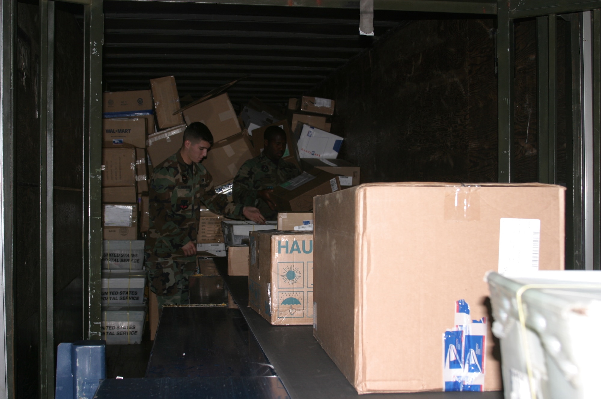 Airmen 1st Class Robert Zaldivar and Michael Smith, both with Detachment 3 Pacific Air Forces Air Postal Squadron, offload holiday mail and packages from a semi-truck trailer Nov. 29. In addition to regular mail, Aerial Mail Terminal professionals receive two, sometimes three, trailers of bulk mail such as magazines.
(U.S. Air Force/Senior Airman Nestor Cruz)