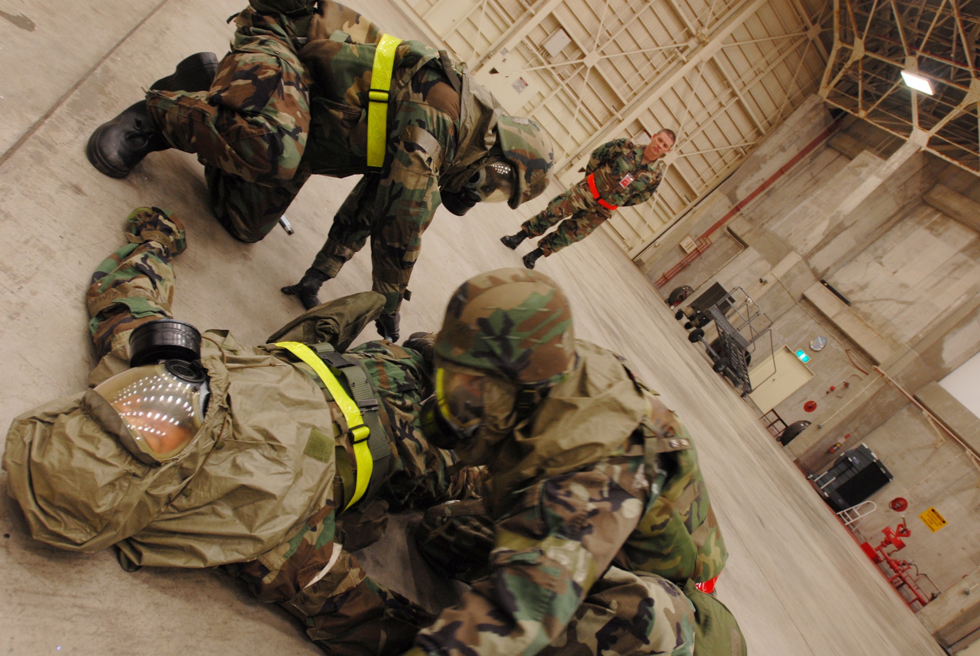 Tech. Sgt. Forest Sell and Senior Airman Victor Cross don Senior Airman Tyler Willing's mask for him and determine that they need to administer the Antidote Treatment Nerve Agent Auto-Injector in a scenario while Exercise Evaluation Member Master Sgt. Jefferson Baggett watches their progress during Local Operational Readiness Exercise Beverly High 08-2 at Kadena Air Base, Japan, Dec. 4, 2007. These scenarios enable base agencies to work together, mitigate real-world situations, and heighten readiness capabilities. All Airmen are from the 718th Aircraft Maintenance Squadron 961st Aircraft Maintenance Unit. (U.S. Air Force photo/Staff Sgt. Chrissy FitzGerald) 