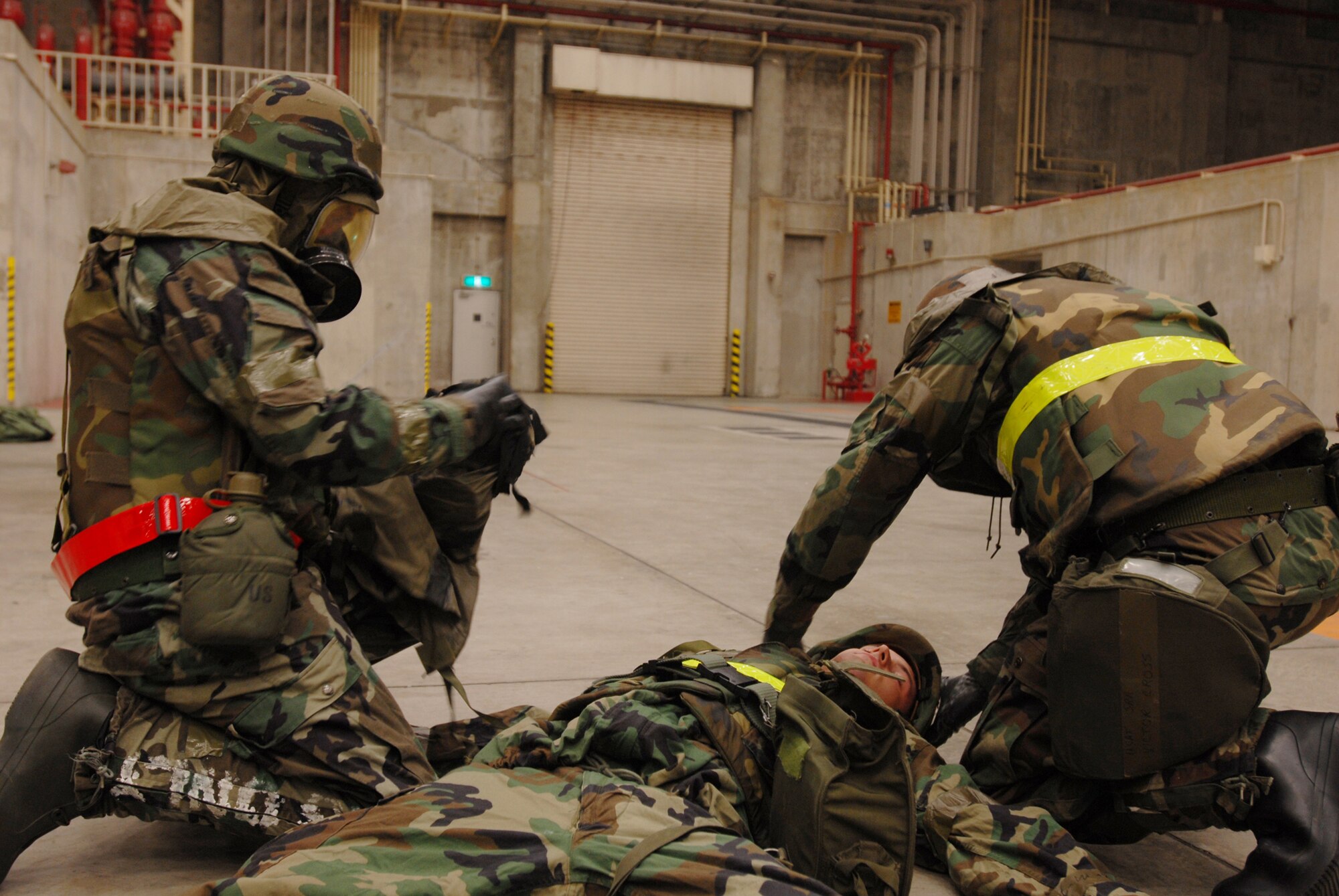 Tech. Sgt Forest Sell and Senior Airman Victor Cross assess Senior Airman Tyler Willing's condition and determine the next course of action for the auto-injector scenario during Local Operational Readiness Exercise Beverly High 08-2 at Kadena Air Base, Japan, Dec. 4, 2007. These scenarios enable base agencies to work together, mitigate real-world situations, and heighten readiness capabilities. All Airmen are from the 718th Aircraft Maintenance Squadron 961st Aircraft Maintenance Unit. 
(U.S. Air Force photo/Staff Sgt. Chrissy FitzGerald) 
