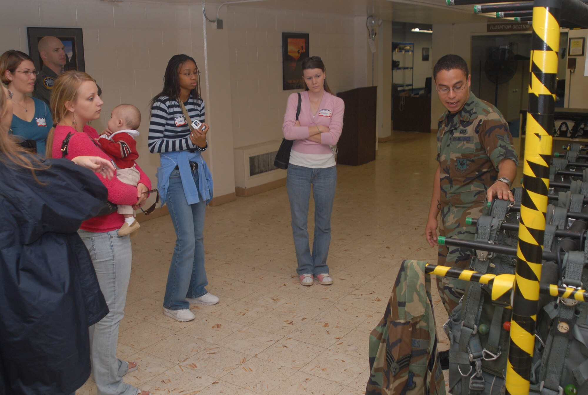 Airman 1st Class Jonathan Potter, 18th Operations Support Squadron, briefs a group of spouses about the use of aircraft life support equipment as part of a tour through the unit Nov. 30, 2007. The squadron opened its doors to the spouses as a way of thanking them for their support.  (U.S. Air Force photo/Staff Sgt. Christopher A. Marasky)