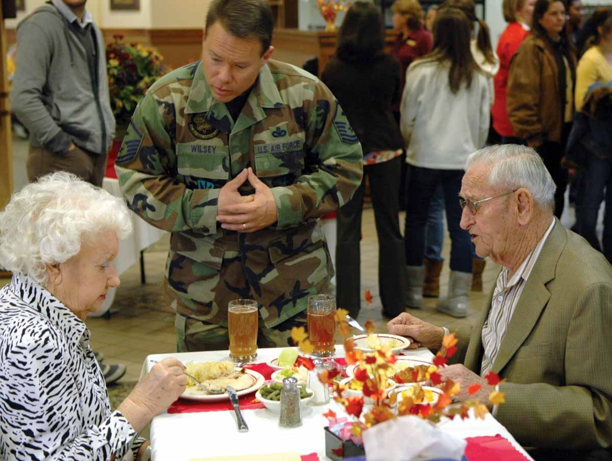 Master Sgt. Michael Wilsey, 552nd Maintenance Operations Squadron first sergeant, visits with retirees who attended the Thanksgiving Day event. (Air Force photo by Kathy Paine)