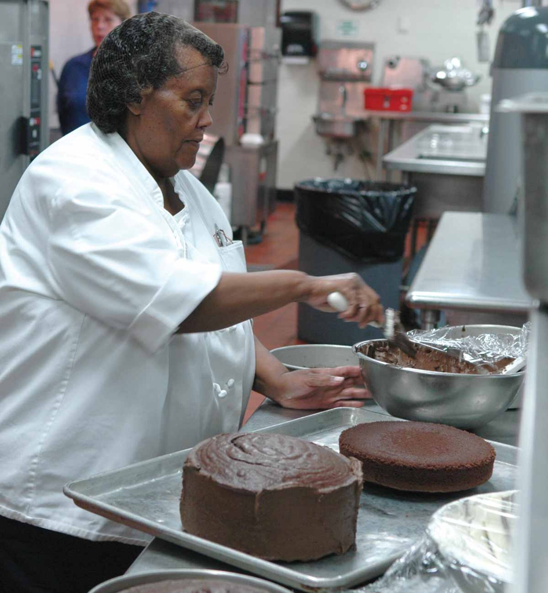 Prentiss Long, baker, puts the finishing touches on one of the 10 cakes she prepared for after dinner desserts. Ms. Long also baked 45 pies for the Thanksgiving Day dinner. An employee of the Dale Rogers Center, Ms. Long has been making desserts for military personnel who eat at the Vanwey Dining facility since 1981.  (Air Force photo by Kathy Paine)