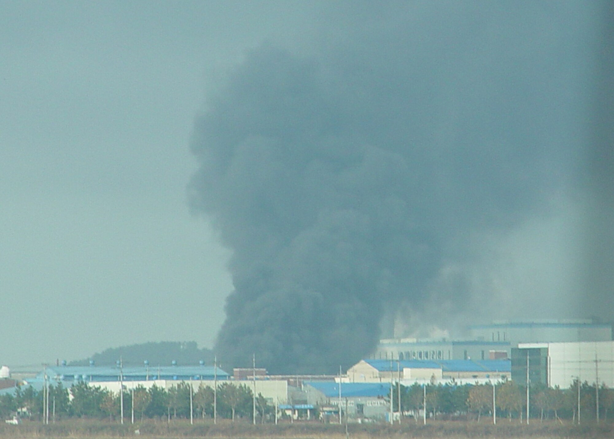 Smoke from an industrial building can be seen from the road here Dec. 3. Airmen from the 8th Civil Engineer Squadron fire department, assisted local fire departments to put out a large industrial fire. (U.S. Air Force photo/Tech. Sgt. Jason Rosenbaum)               