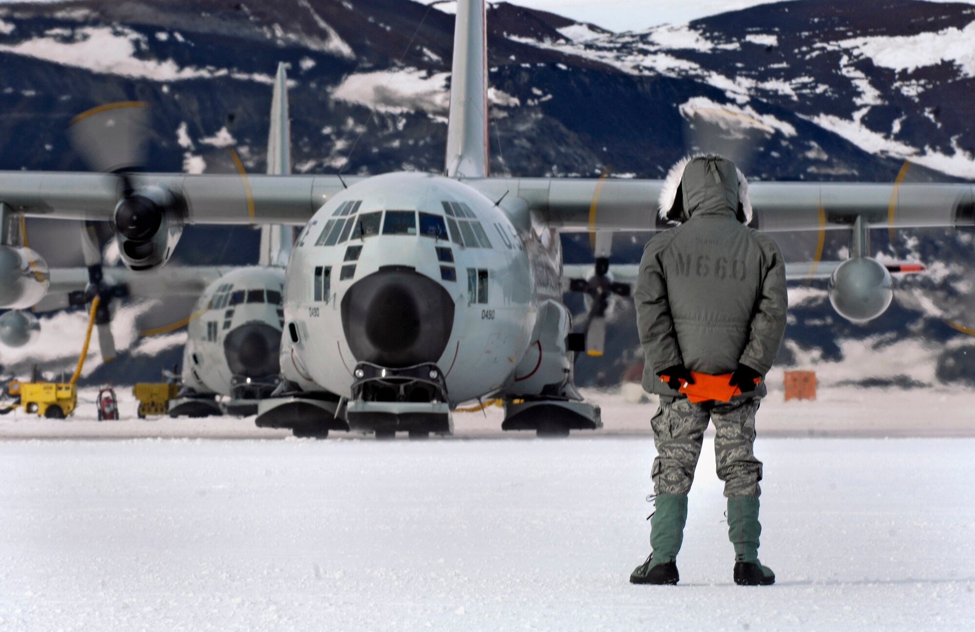 Tech. Sgt. Kevin Call waits to marshal an LC-130 Hercules from its parking spot on the annual sea ice runway Nov. 26 near McMurdo Station, Antarctica, during Operation Deep Freeze. Sgt. Call is a crew chief with the New York Air National Guard's 109th Airlift Wing. Ski-equipped LC-130s, crews and support personnel are supporting the 13th Air Force-led Joint Task Force Support Forces Antarctica, Operation Deep Freeze. Operation Deep Freeze is a unique joint and total force mission that has supported the National Science Foundation and U.S. Antarctic Program that began in 1955. (U.S. Air Force photo/Tech. Sgt. Shane A. Cuomo) 