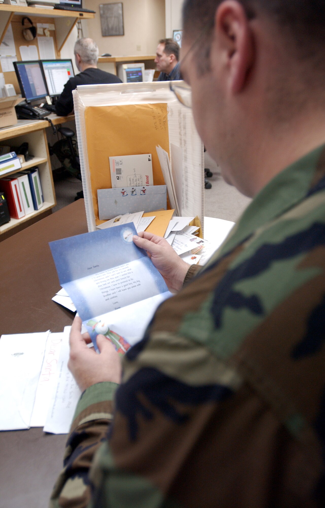 EIELSON AIR FORCE BASE, Alaska -  Staff Sgt. Matthew Bohlman, 354th Operations Support Squadron weather technician, reads a letter from Hayes Kohler, a girl who lives in Europe, while coordinating the Santa's Mailbag program here at Eielson AFB, Alaska, Nov. 26, 2007. The 354th Operations Support Squadron's Santa's Mailbag program reads and responds to letters written from children all over the world. This program has been active for 53 years and is a holiday tradition for the men and women of the 354th Operation Support Squadron. (U.S Air Force photo by Staff Sgt Eric T. Sheler)
