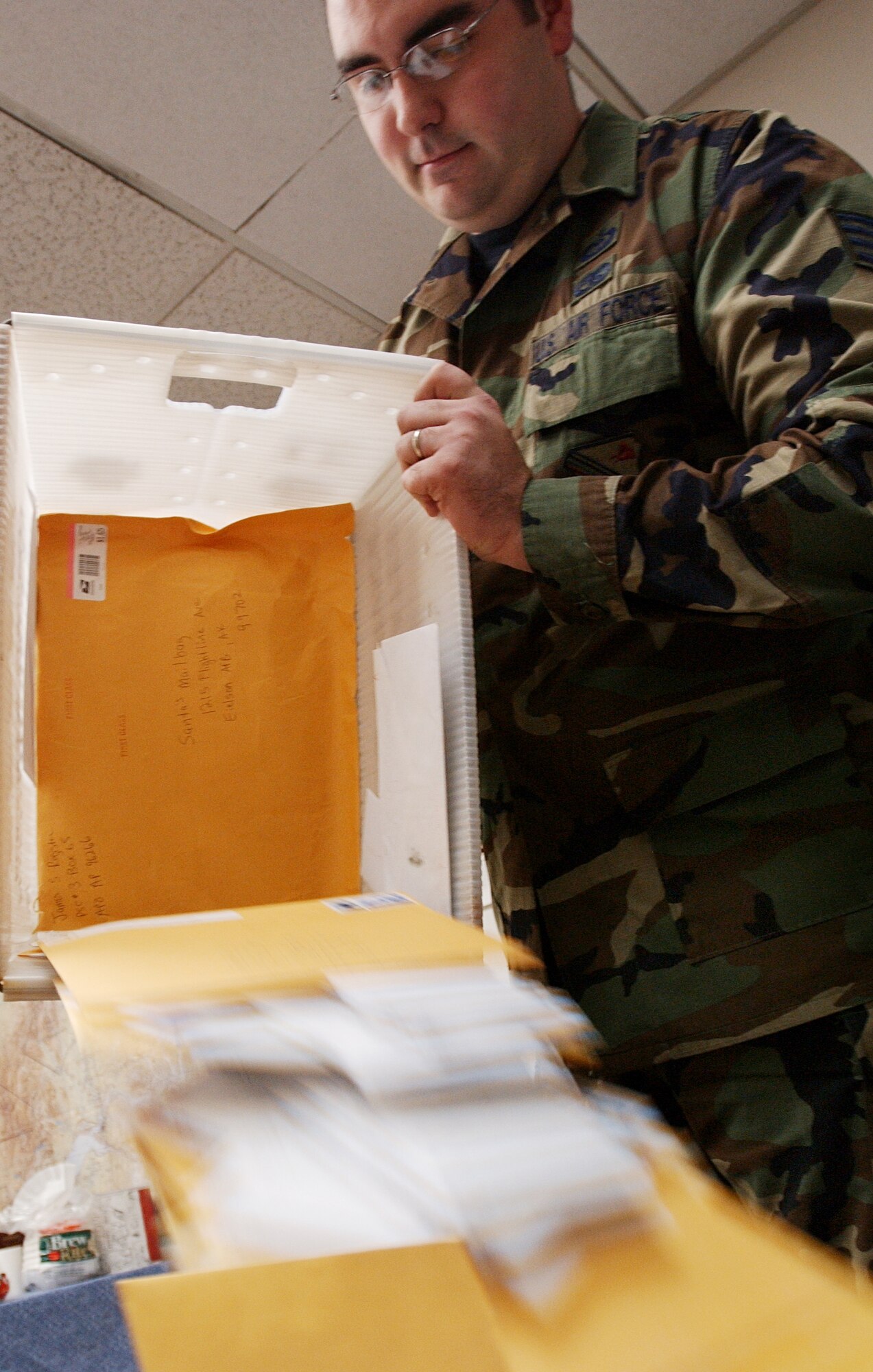EIELSON AIR FORCE BASE, Alaska - Staff Sgt. Matthew Bohlman, 354th Operations Support Squadron weather technician, casts out letters received from children all over the world in preparation to read and respond to the children's letters as a part of the Santa's Mailbag program here at Eielson AFB, Nov. 26, 2007. This program has been active for more than 50 years and is a holiday tradition for the men and women of the 354th Operation Support Squadron. (U.S Air Force photo by Staff Sgt Eric T. Sheler)
