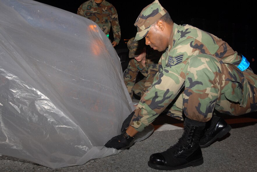Airmen from the 18th Logistics Readiness Squadron, Vehicle Operations Section secure plastic around a pick-up truck with sandbags in preparation for a simulated chemical attack during Local Operational Readiness Exercise Beverly High 08-2 at Kadena Air Base, Japan, Dec. 3, 2007. These scenarios enable base agencies to work together, mitigate real-world situations, and heighten readiness capabilities.
(U.S. Air Force photo/Staff Sgt. Chrissy FitzGerald)
