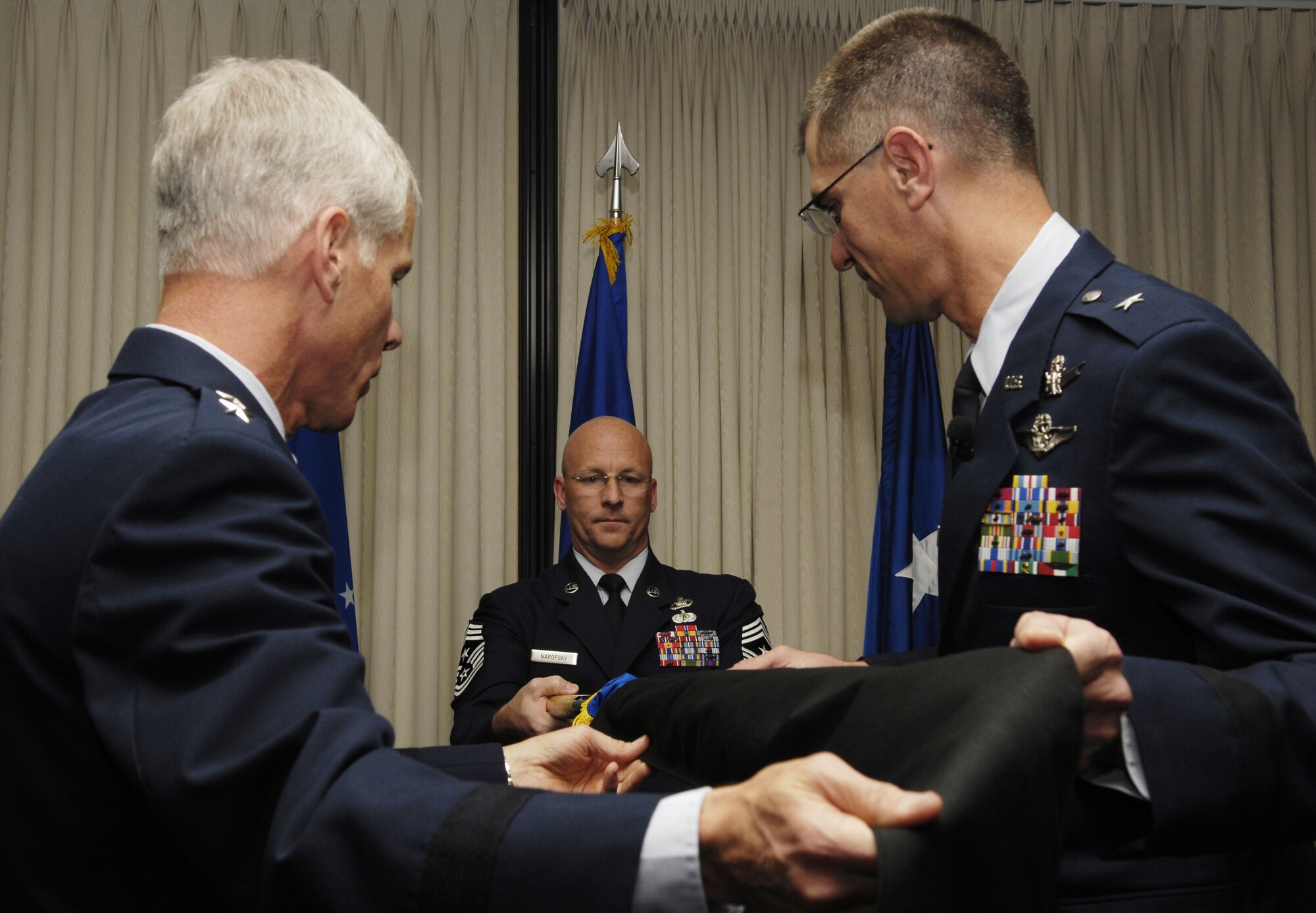 VANDENBERG AIR FORCE BASE, Calif. -- Maj. Gen. William Shelton, 14th Air Force commander, removes the sheath of the personal flag being presented to  Brig. Gen. Jay Santee during his promotion ceremony on Nov. 24. All general officers are issued a rank specific flag upon the promotion of each star. (U.S. Air Force photo/Airman 1st Class Christian Thomas)