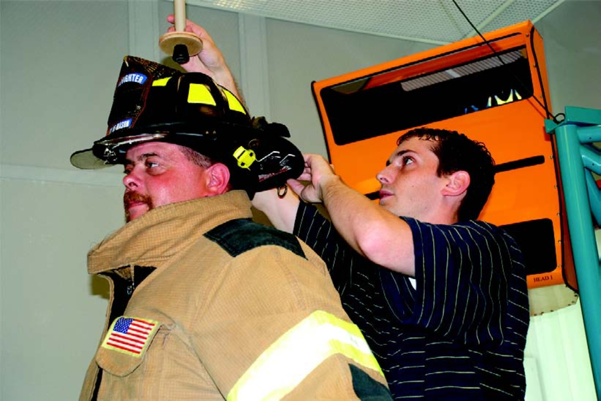 Anthropometry specialist Mark Boehmer (right), of General Dynamics Advanced Information Systems, prepares firefighter Paul Bauer, a 19-year veteran and part-time firefighter engineer with the city of Mason (Ohio) Fire Department, for a three-dimensional scan dressed in full turnout gear (photo by AFRL’s Chris Gulliford).
