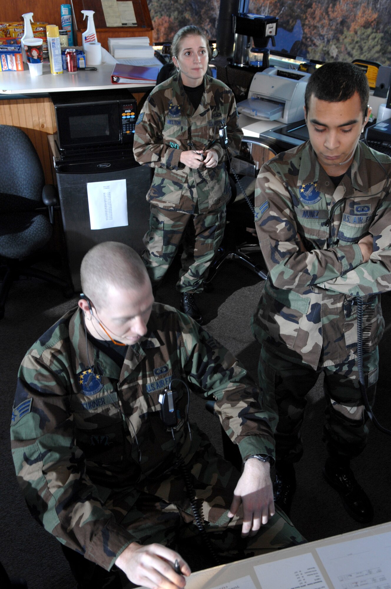 Staff Sergeant (SSgt) Camilla Melton (back), supervises her troops Senior Airman Carson Turner and Airman First Class Oscar Nunez, both Air Traffic Controllers from the 4th Operations Support Squadron on November 29, 2007 at Seymour Johnson AFB, North Carolina.  SSgt Melton is the only female Watch Supervisor at Seymour Johnson AFB, which is one of the most demanding positions as an Air Traffic Controller.    
	
(US Air Force photo by Airman First Class Salma Din)(Released)
