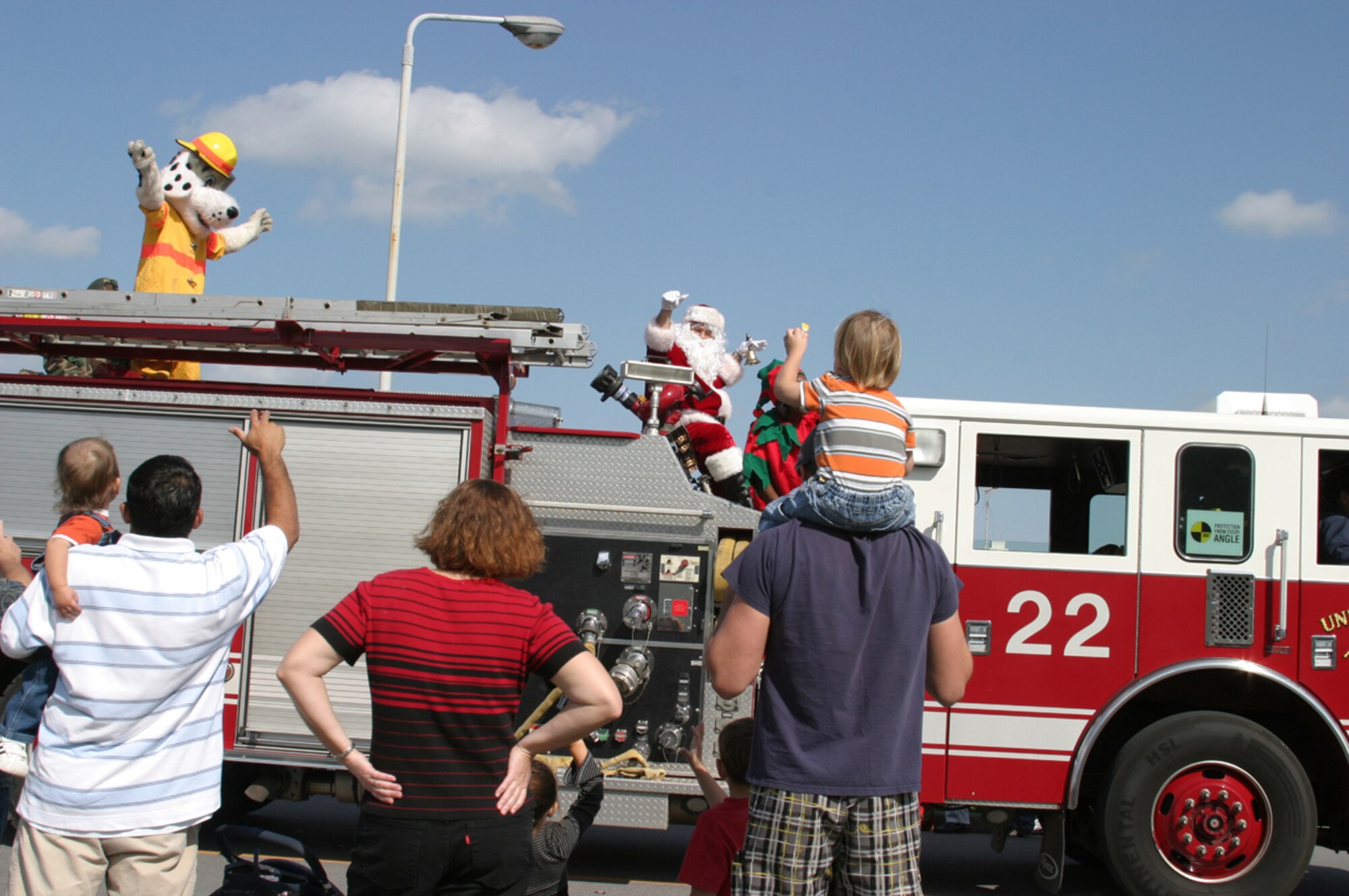 Sparky and Santa Claus wave to the crowd during the 2007 Holiday Parade Dec. 1 at Kadena Air Base, Japan. The parade featured numerous organizations and kicked off the Tinsel Town celebration at the Schilling Community Center. 