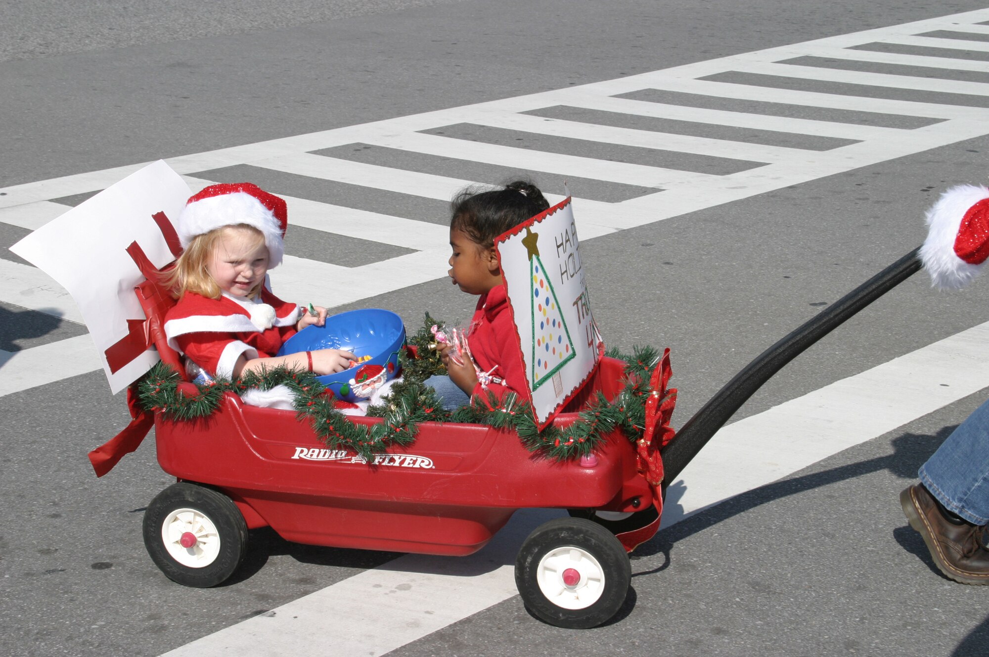 Breiann Bergman and Isabela West throw candy to the crowd during the 2007 Holiday Parade Dec. 1 at Kadena Air Base, Japan. The parade featured numerous organizations and kicked off the Tinsel Town celebration at the Schilling Community Center. 