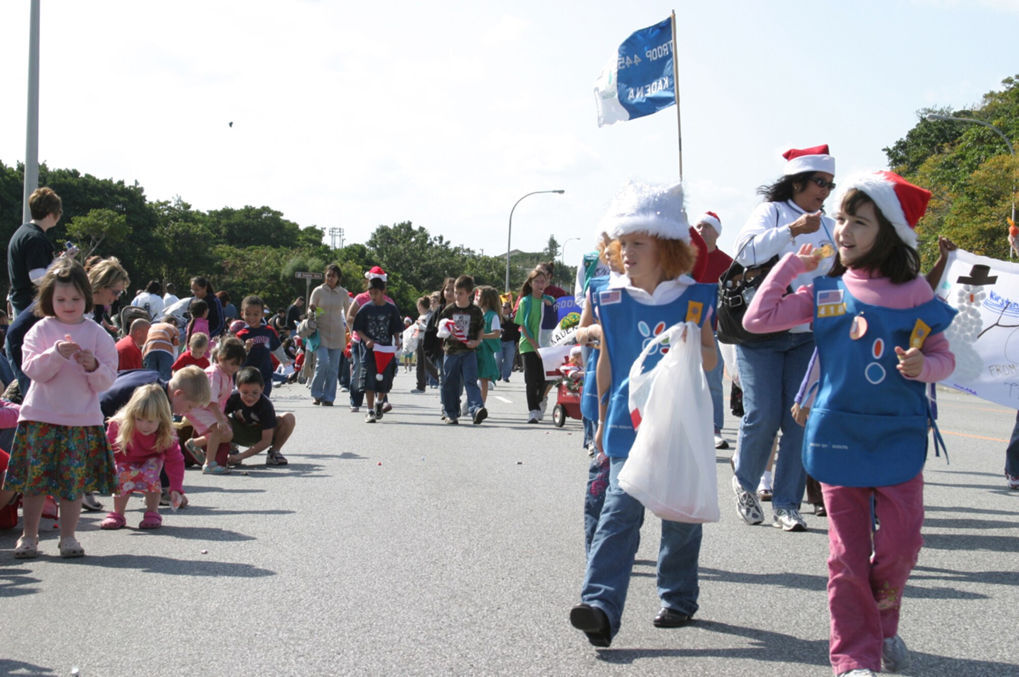 Children pick up candy thrown by participants of the 2007 Holiday Parade Dec. 1 at Kadena Air Base, Japan. The parade featured numerous organizations and kicked off the Tinsel Town celebration at the Schilling Community Center. 