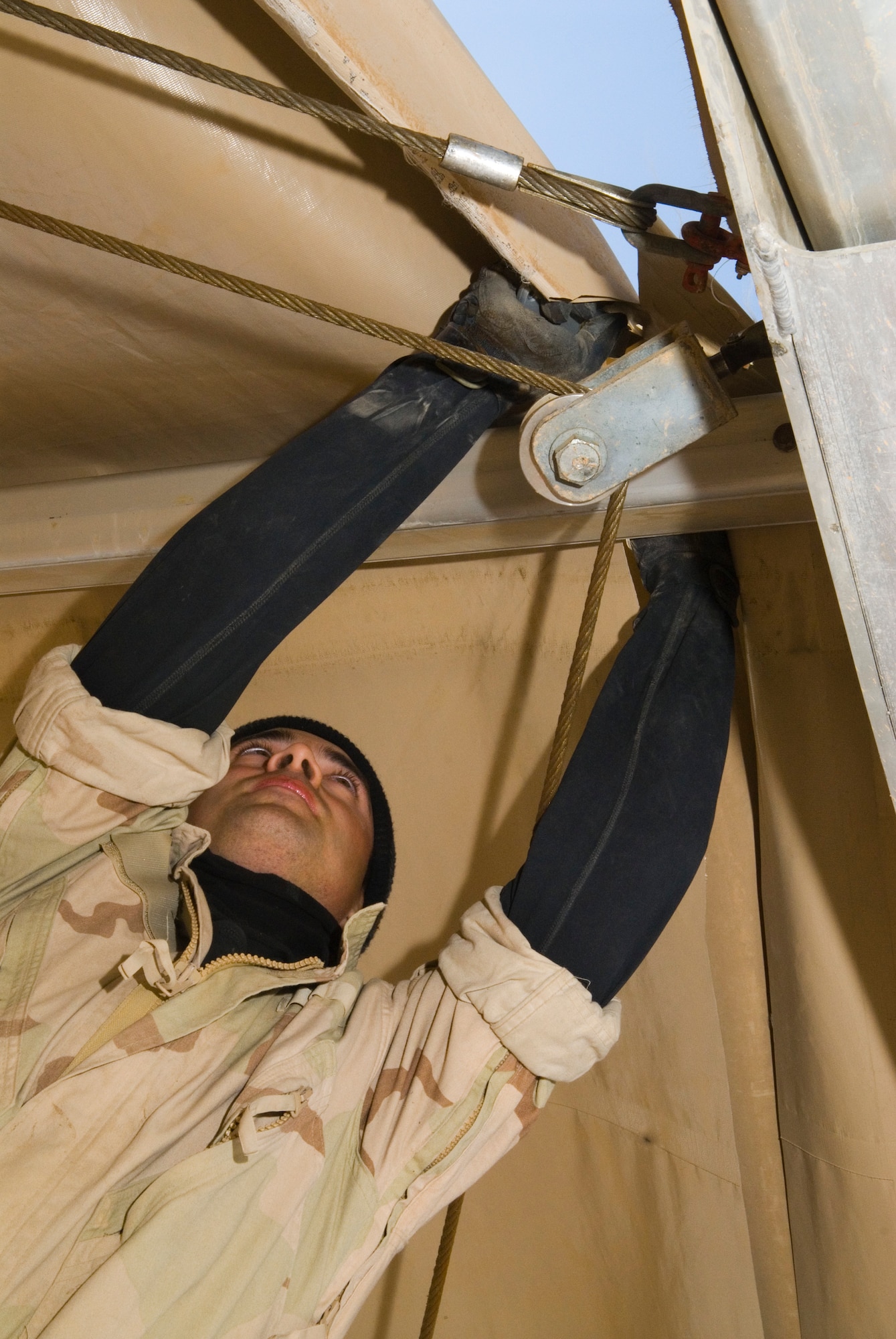 BALAD AIR BASE, Iraq -- Staff Sgt. Adam Boubede, a 332nd Expeditionary Civil Engineer Squadron mobile team member, cuts the roof tarp from a Basic Expeditionary Airfield Resources dome shelter here, Dec. 3.  The shelter was used to store supplies for 332nd Expeditionary Services Squadron. Sergeant Boubede is deployed from Holloman Air Force Base, N.M. (U.S. Air Force photo/Staff Sgt. Joshua J. Garcia) 
