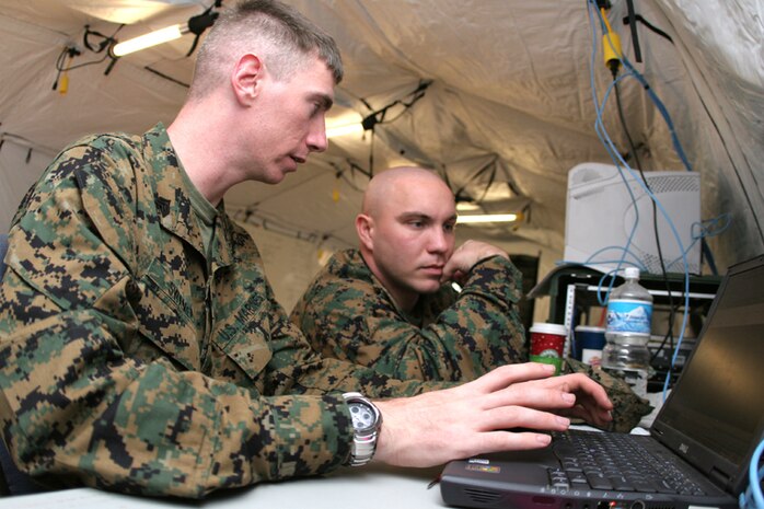 (From left) Sgt. David J. Swaney, MWSS-171 tactical data networking specialist and native of Kelseyville, Calif., and Cpl. Joseph Killian, Marine Aircraft Group 12 aviation information systems specialist and Birmingham, Ala., native, utilize their technical savvy at Site 1 during Exercise Wolmi-Do Fury 2007 at Kadena Air Base Dec. 3.