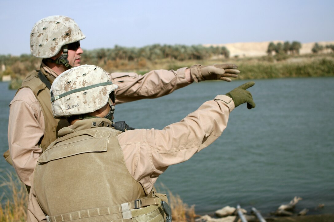 AL QA?IM, Iraq ? Sgt. Craig L. O?Dell (left), the Civil Affairs Ramana team leader of the Civil Affairs Team from 5th Battalion, 10th Marine Regiment, of Task Force 3rd Battalion, 2nd Marine Regiment, Regimental Combat Team 2, observes the progress of a water treatment facility with his interpreter along the Euphrates River in Ubaydi, Dec. 4. Working hand in hand with local government officials, the Civil Affairs Group helps plan and oversee projects such as water treatment facilities, radio and television stations, trash removal and road and bridge repair.