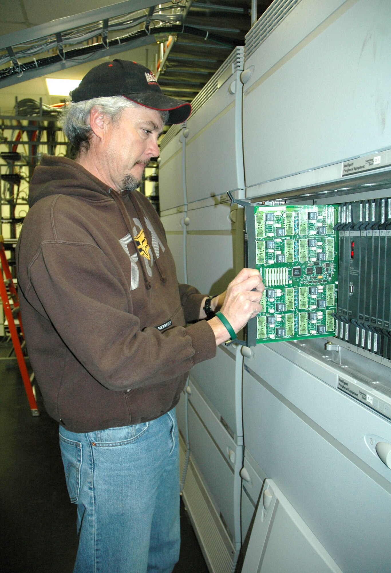 Brian Martinez, 341st Communications Squadron cable splicer and switch technician, installs a line card, which is used for analog and digital phone lines Nov. 26. The telephone maintenance staff support more than 4,500 users on base, and is one of the 15 work centers who contributed to the zero safety discrepancies from July 2006 to July 2007. Their combined efforts earned the Akima Corporation President's Safety Award for 2007. (U.S. Air Force photo/Senior Airman Eydie Sakura).