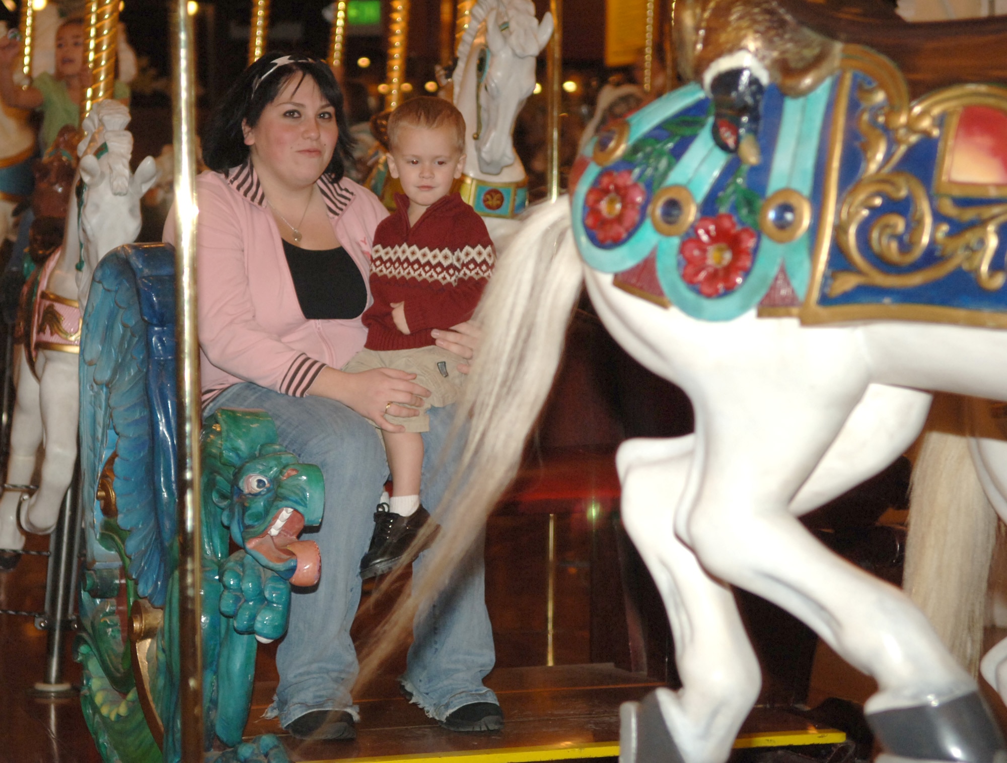 FAIRCHILD AIR FORCE BASE, Wash. – Donovan Lopez, 22 months old, rides the carrousel with a family friend, Angel Garcia, at the carrousel in Riverfront Park, downtown Spokane on Nov. 30. Operation Spokane Heroes hosted a holiday party for families of deployed military members from the local; children visited with Santa, rode the carrousel and enjoyed pizza as part of the festivities. (U.S. Air Force photo by Airman 1st Class Jocelyn A. Ford)
