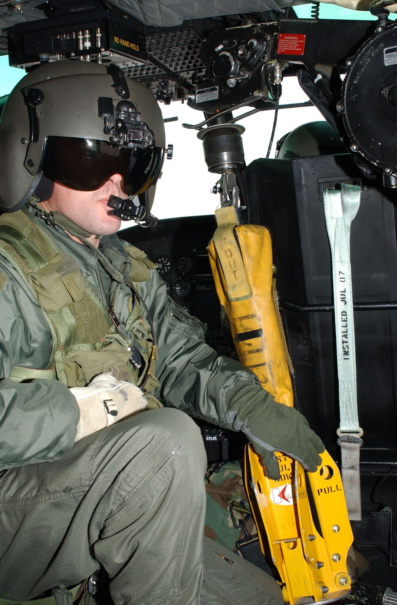 Staff Sgt. Michael Frances, 40th Helicopter Squadron flight engineer, prepares to lower the yellow Forest Penetrator, which is used to insert medical technicians into a wooded area during a search and rescue operation, during a training sortie Nov. 19. (U.S. Air Force photo/Senior Airman Eydie Sakura).