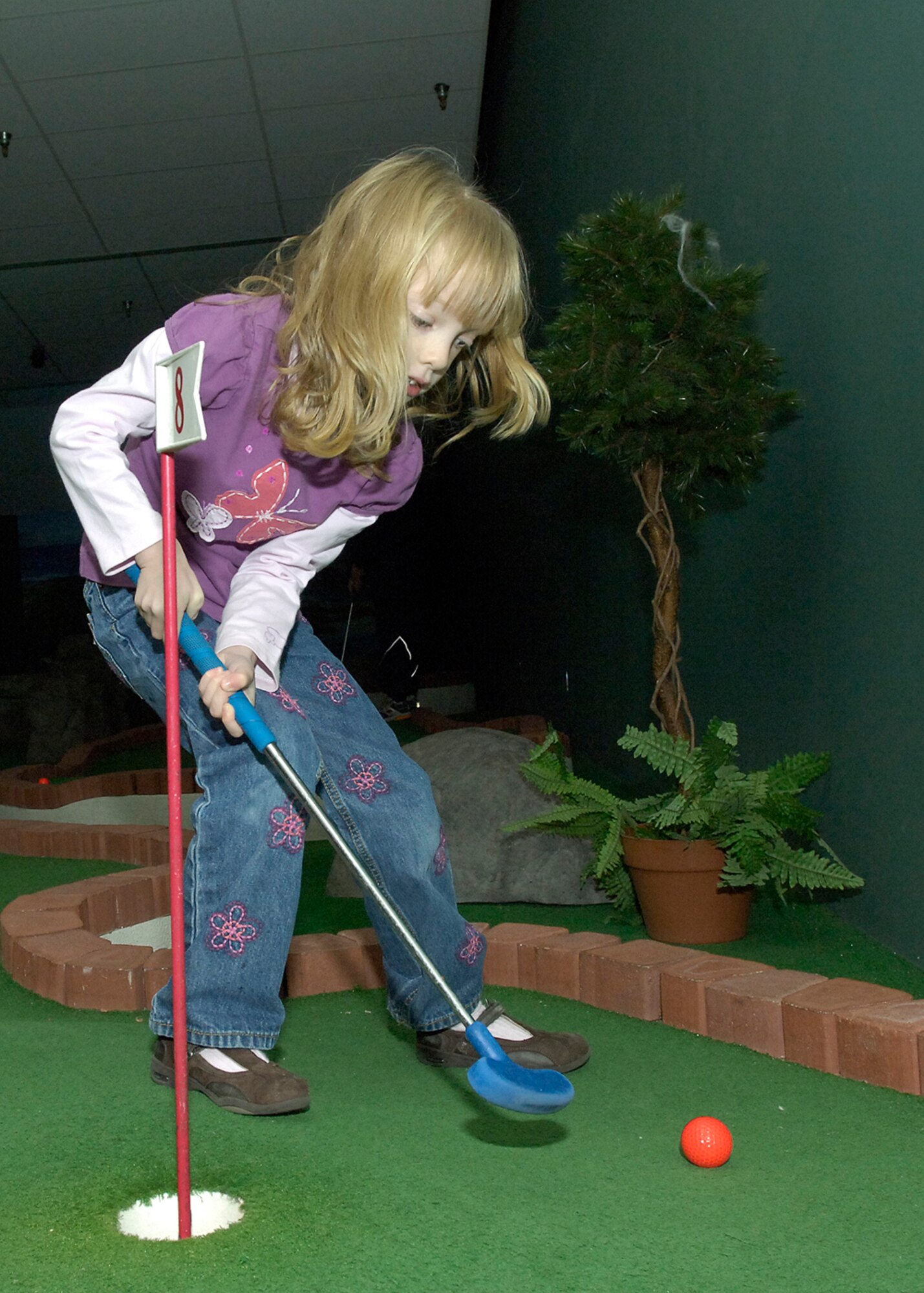 FAIRCHILD AIR FORCE BASE, Wash. – Molly Robinson, daughter of Maj. Mark Robinson, 336th Training Squadron, enjoys a game of mini-golf at the FunSpot Nov. 30 where participants at the Family Fun Night Party were able to take advantage of free bowling, skating, mini-golf, batting cages, and pizza and soda. (U.S. Air Force Photo / Senior Airman Eunique Stevens)