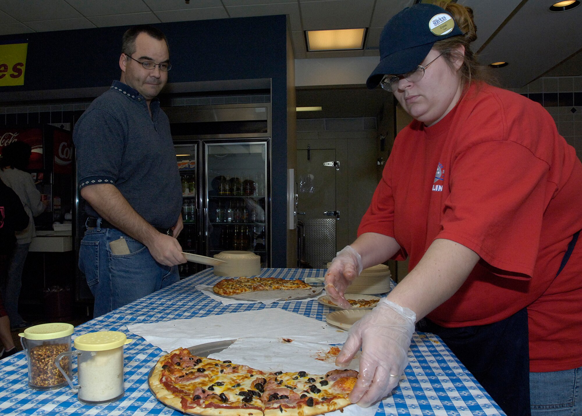 FAIRCHILD AIR FORCE BASE, Wash. – Crystal Kuntz, a Fun Spot employee, serves pizza to Tech. Sgt. Rocky Miller, 92nd Air Refueling Squadron, Nov. 30 at the FunSpot. Pizza, soda, bowling, skating, mini-golf, and the batting cages were available free to those who attended the Family Fun Night Party. (U.S. Air Force Photo / Senior Airman Eunique Stevens)