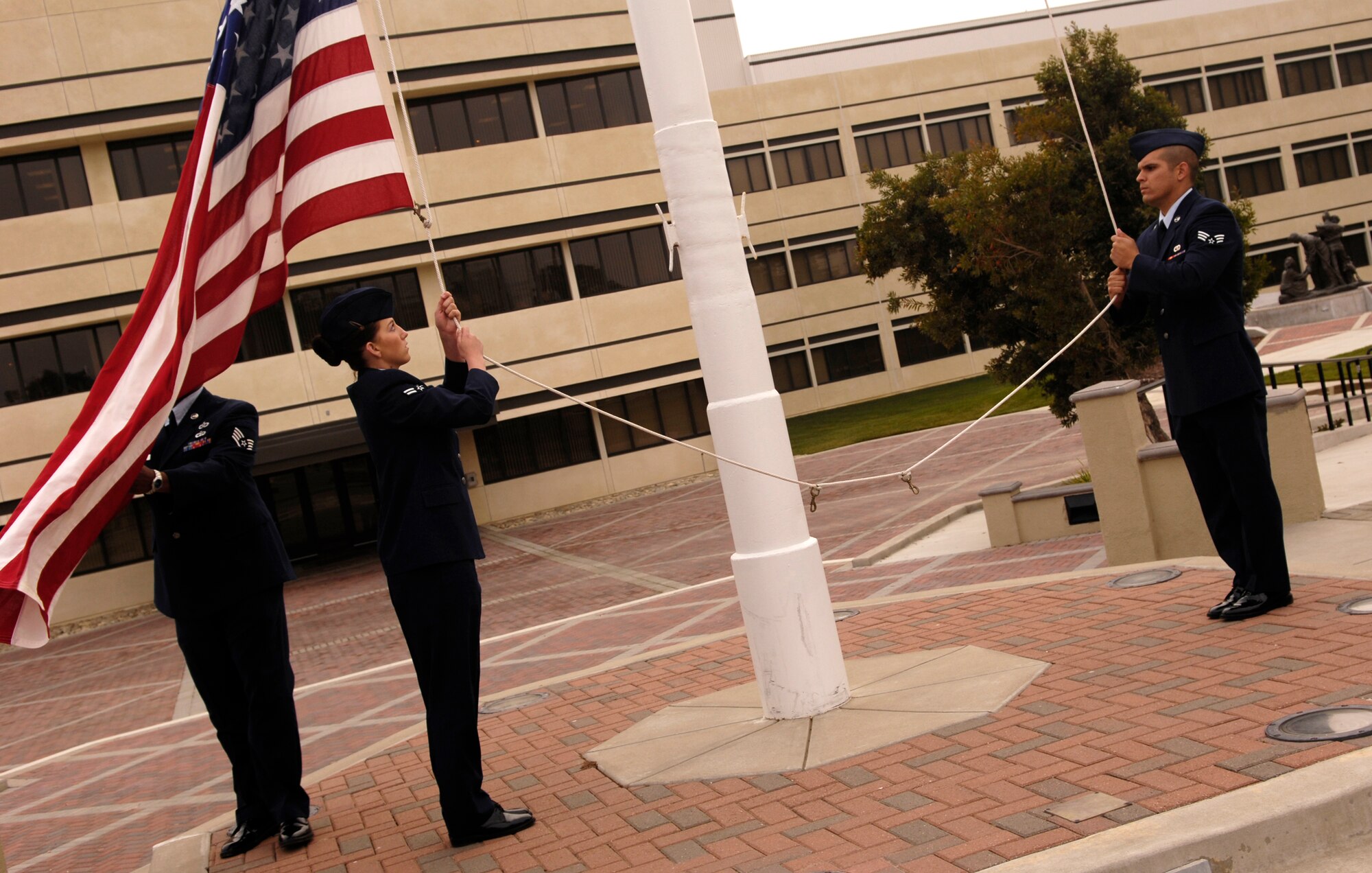 VANDENBERG AIR FORCE BASE, Calif. -- Airmen lower the flag during a retreat ceremony at the headquarters building on Oct. 25. 30th Mission Support Group Airmen supported the time honored open ranks inspection. Air Force Instruction 36-2903 directs the wear of uniforms, insignias, awards and decorations. Airmen of all ranks are required to have all uniform items ready to wear at any time. (U.S. Air Force photo/Airman 1st Class Christian Thomas) 

