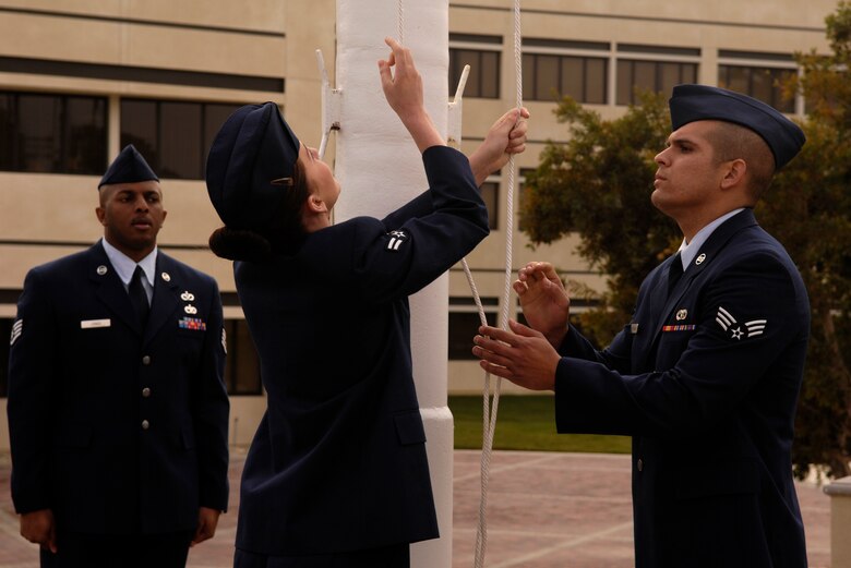 VANDENBERG AIR FORCE BASE, Calif. -- Airmen lower the flag during a retreat ceremony at the headquarters building on Oct. 25. 30th Mission Support Group Airmen supported the time honored open ranks inspection. Air Force Instruction 36-2903 directs the wear of uniforms, insignias, awards and decorations. Airmen of all ranks are required to have all uniform items ready to wear at any time. (U.S. Air Force photo/Airman 1st Class Christian Thomas) 