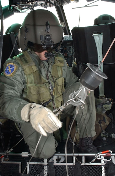 Staff Sgt. Michael Frances, 40th Helicopter Squadron flight engineer, hooks up a stokes litter, a stretcher designed to transport people from the ground to the helicopter while in the air, during a search and rescue training sortie Nov. 19. The stokes litter has multiple attach points, separate hold-down cables and powered extension hoists to help save more lives. (U.S. Air Force photo/Senior Airman Eydie Sakura).