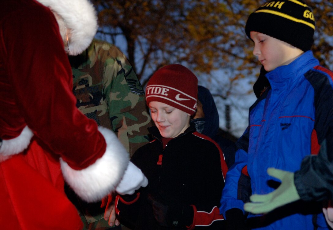 LANGLEY AIR FORCE BASE, Va -- Xander Collins (center), son of Capt. Jason Collins, and Sean McCall (right), son of Army Lt. Col. Mike McCall, assigned to Fort Monroe, receive gifts from Santa Claus during the Langley holiday tree lighting Dec. 2. Community members gathered to light the tree and sing Christmas carols to celebrate the holiday season. (U.S. Air Force photo/Airman 1st Class Vernon Young)