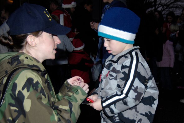 HANSCOM AFB, Mass. – Staff Sgt. Lori Strogoff, 66th Medical Support Squadron, helps her son, Dominic, unwrap a piece of candy from Santa during the tree lighting ceremony Nov. 29. (U.S. Air Force photo by Linda LaBonte Britt)