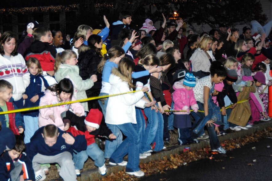 HANSCOM AFB, Mass. – Happy Hanscom children hurry to grab candies tossed by Santa during his special appearance before the trees outside the Base Chapel are lit Nov. 29. (U.S. Air Force photo by Linda LaBonte Britt)