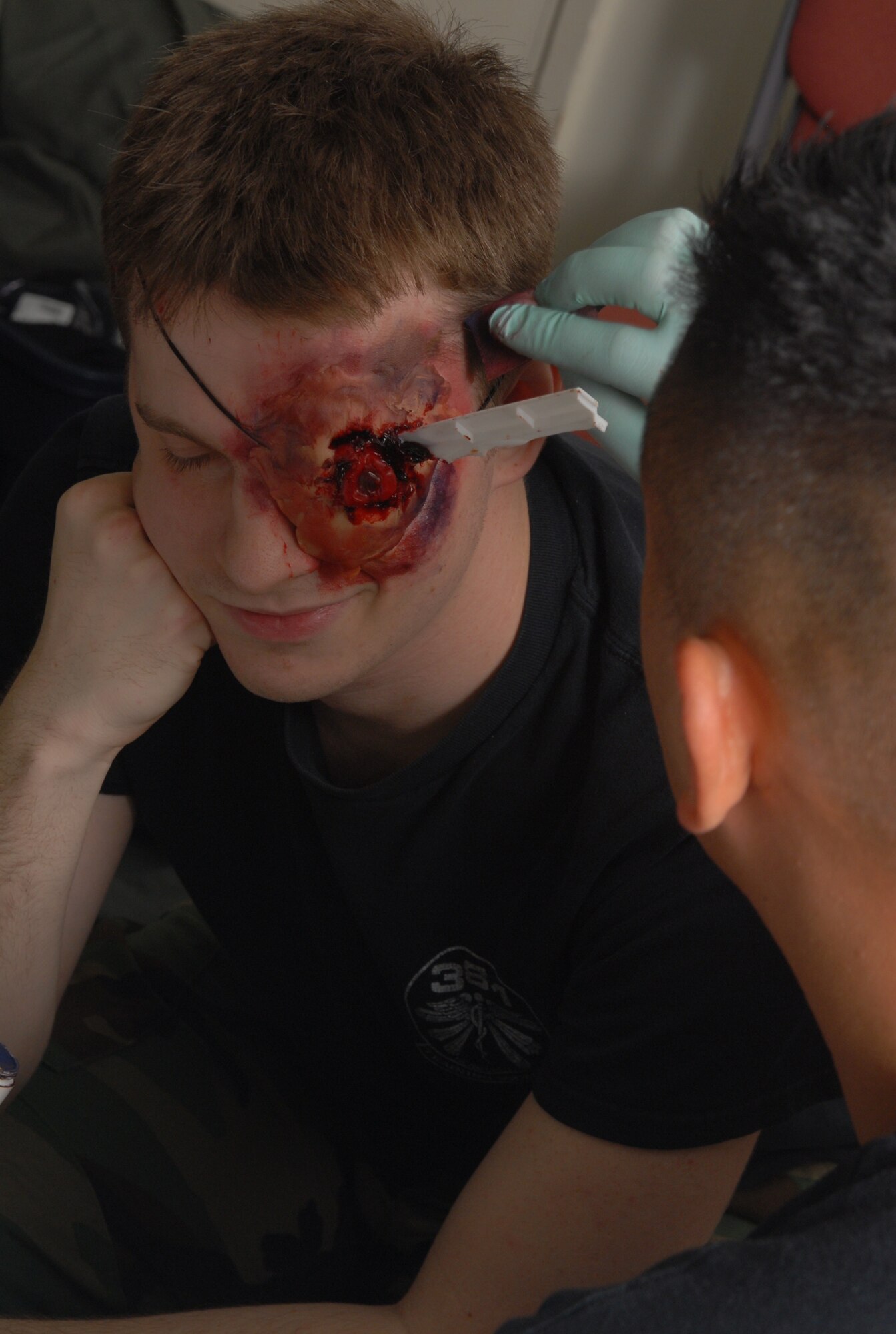 Tech. Sgt. Jay McLaren, an Exercise Evaluation Team member from the 18th Dental Squadron, applies moulage to Airman 1st Class Michael Henseler, a role player from the 18th DS, during Local Operational Readiness Exercise Beverly High 08-2 at Kadena Air Base, Japan, Dec. 4, 2007. Role players are often moulaged in order to add realism to exercise scenarios. These scenarios enable base agencies to work together, mitigate real-world situations, and heighten readiness capabilities. (U.S. Air Force photo/Staff Sgt. Christopher A. Marasky)