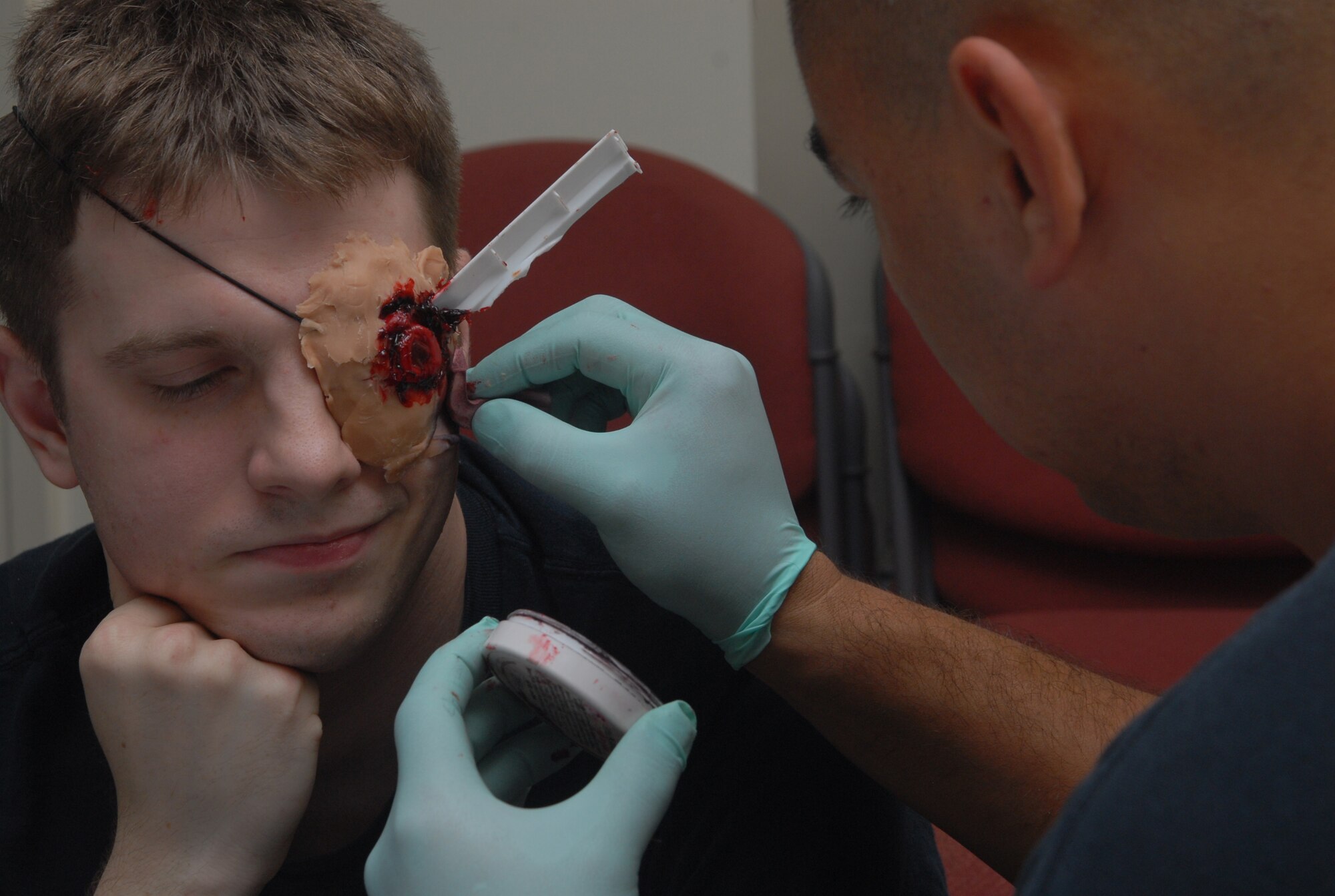 Tech. Sgt. Jay McLaren, an Exercise Evaluation Team member from the 18th Dental Squadron, applies moulage to Airman 1st Class Michael Henseler, a role player from the 18th DS, during Local Operational Readiness Exercise Beverly High 08-2 at Kadena Air Base, Japan, Dec. 4, 2007. Role players are often moulaged in order to add realism to exercise scenarios. These scenarios enable base agencies to work together, mitigate real-world situations, and heighten readiness capabilities. (U.S. Air Force photo/Staff Sgt. Christopher A. Marasky)