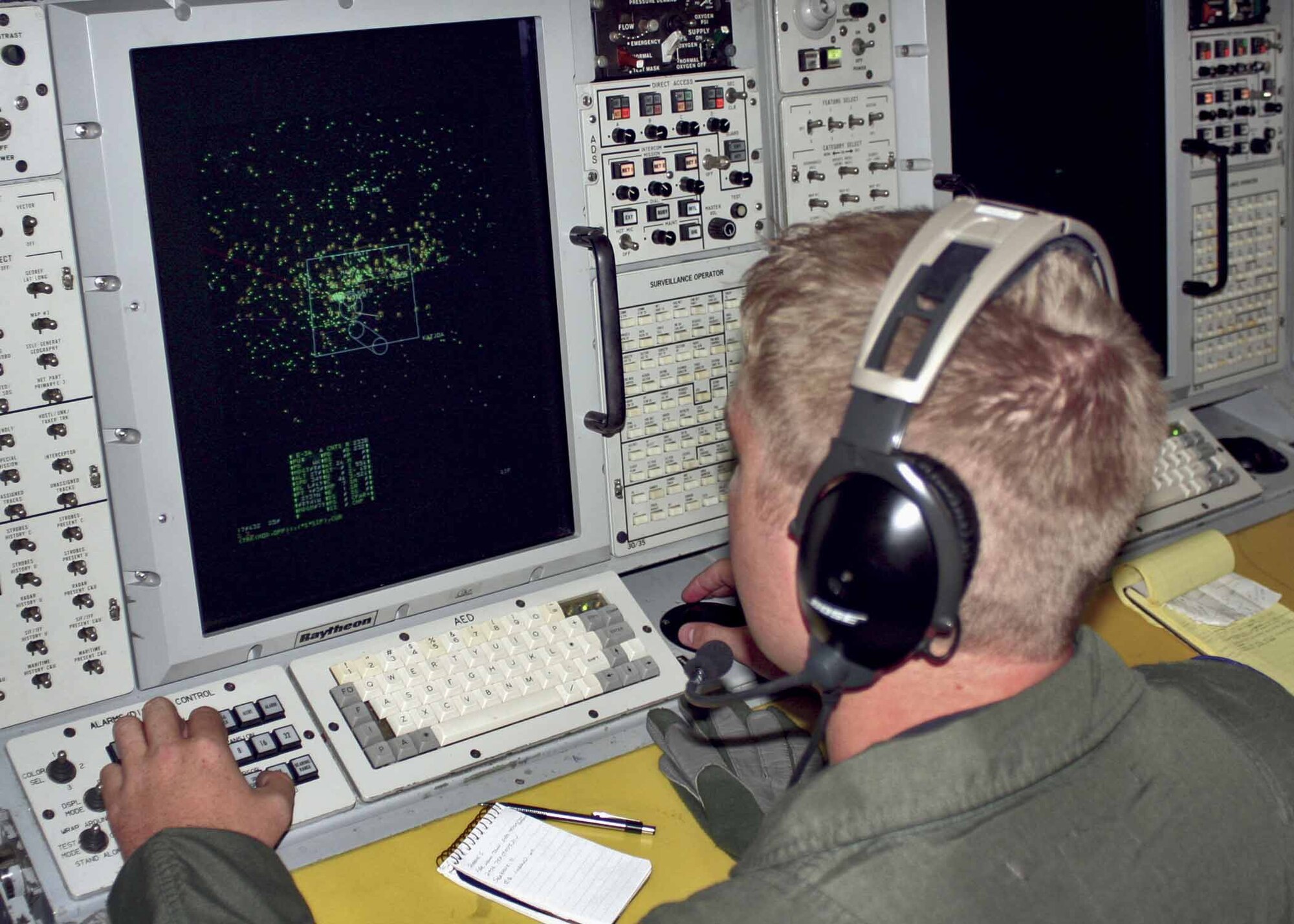 An air weapons officer from the 960th Airborne Air Control Squadron scans the skies with his fellow Airmen while aboard the E-3 Sentry.  (Air Force photo by Staff Sgt. Stacy Fowler)